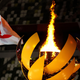 A picture shows the Olympic Flame and Cauldron next to the Japanese and Olympic flags during the opening ceremony of the Tokyo 2020 Olympic Games,